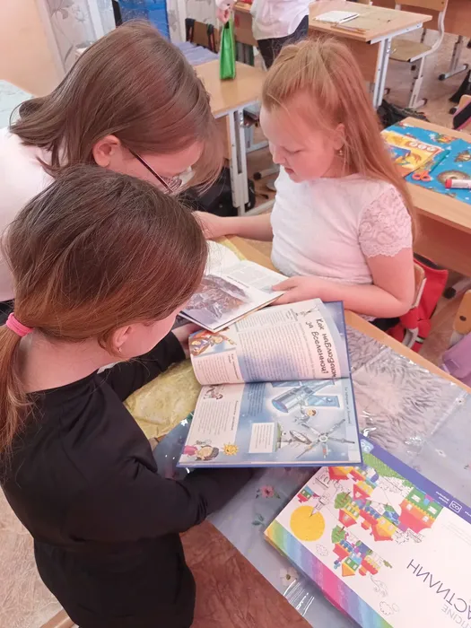 девочки рассматривают энциклопедии